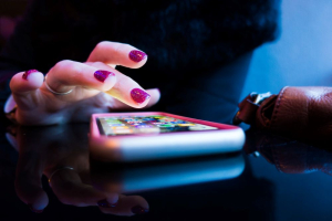 Femme qui utilise son smartpĥone sur une table