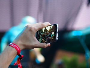 Personne qui filme un événement avec un téléphone portable